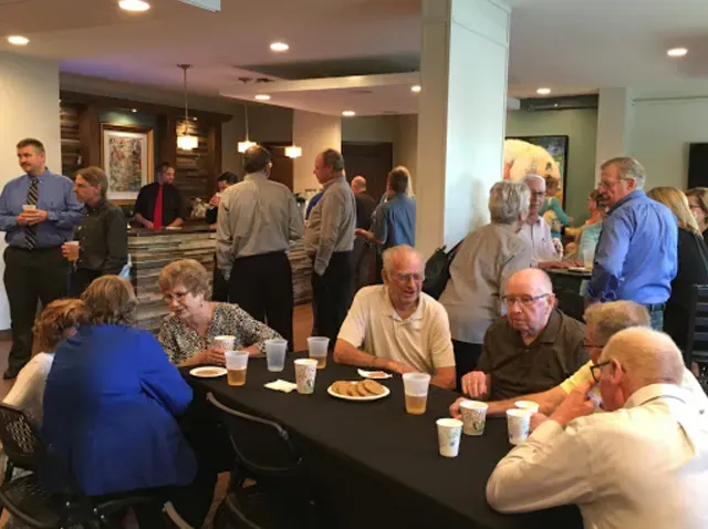 A group of people are sitting at tables eating and drinking