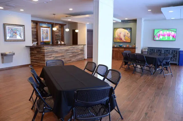 A large room with a table and chairs in it.