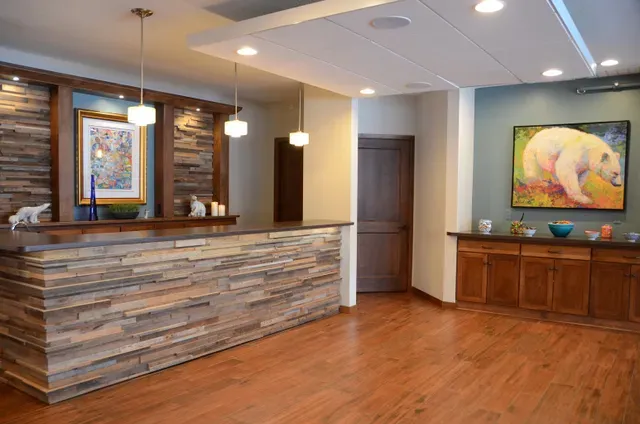 A reception area with a wooden counter and a painting of a polar bear on the wall.