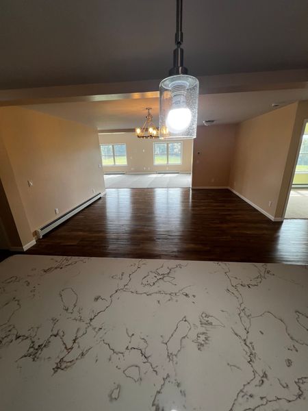 A living room with hardwood floors and a chandelier hanging from the ceiling.