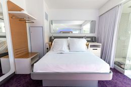 A hotel room with a bed and a mirror