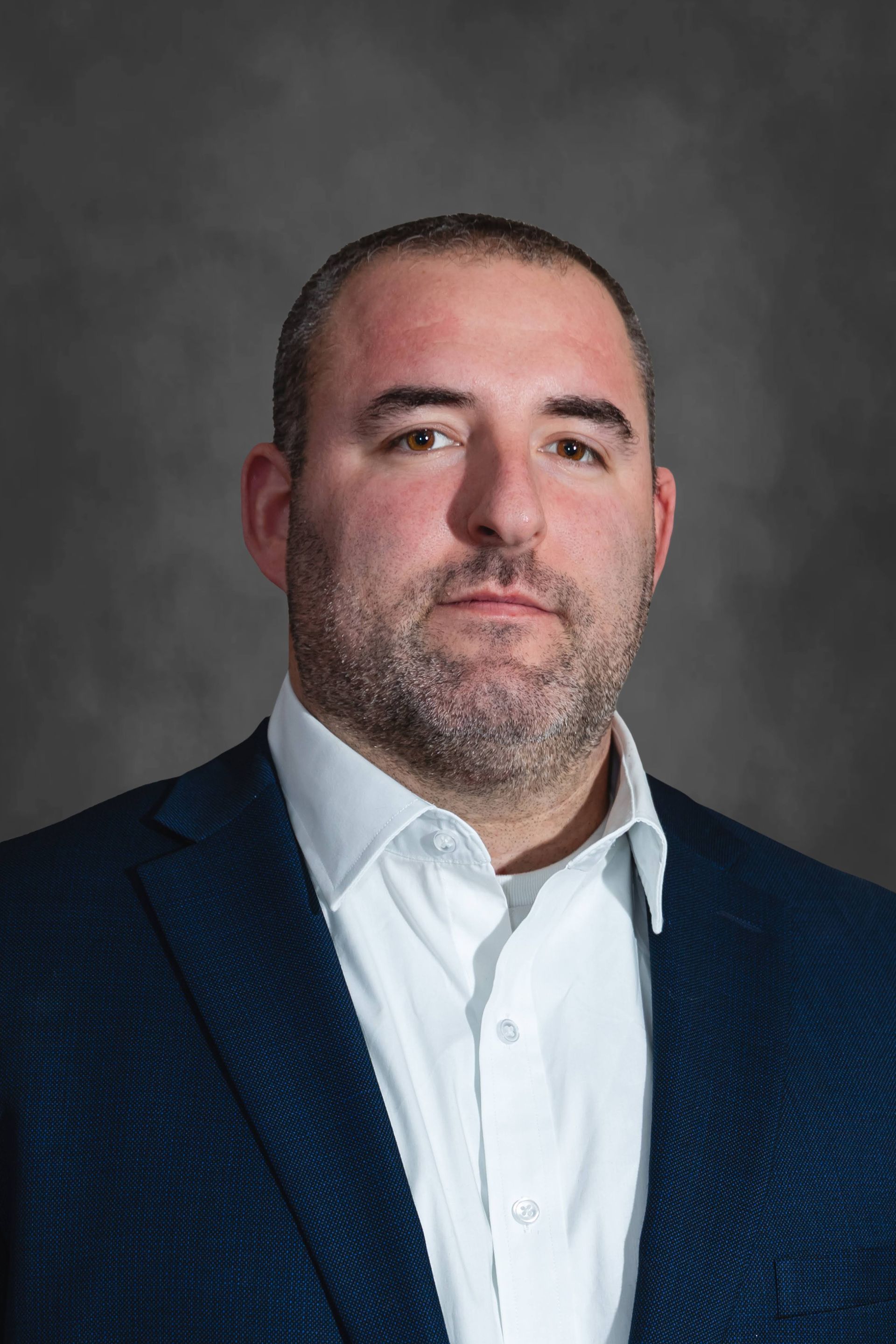 a man with a beard is wearing a black shirt and smiling .