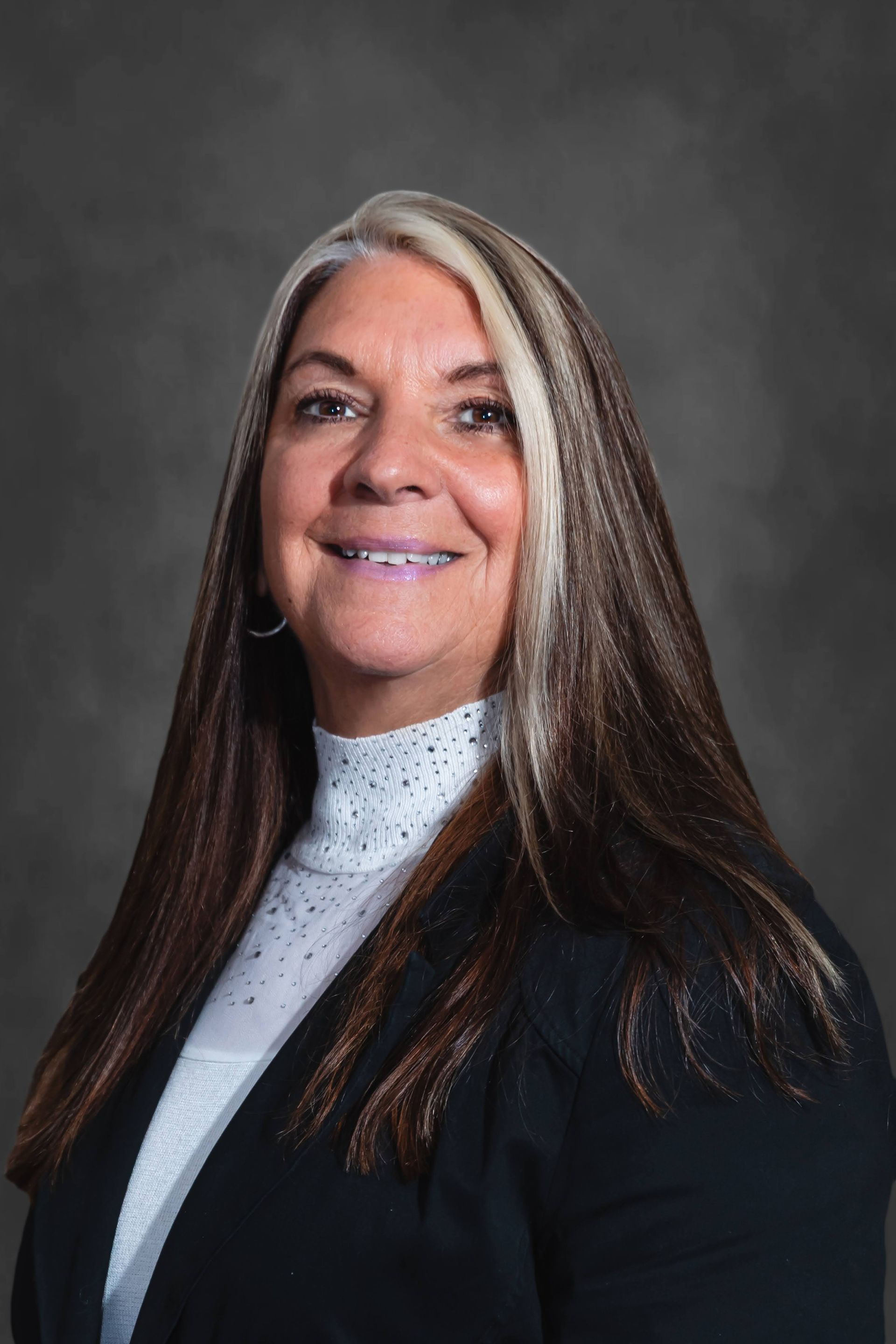 a woman with long blonde hair is wearing a black shirt and a cross necklace .