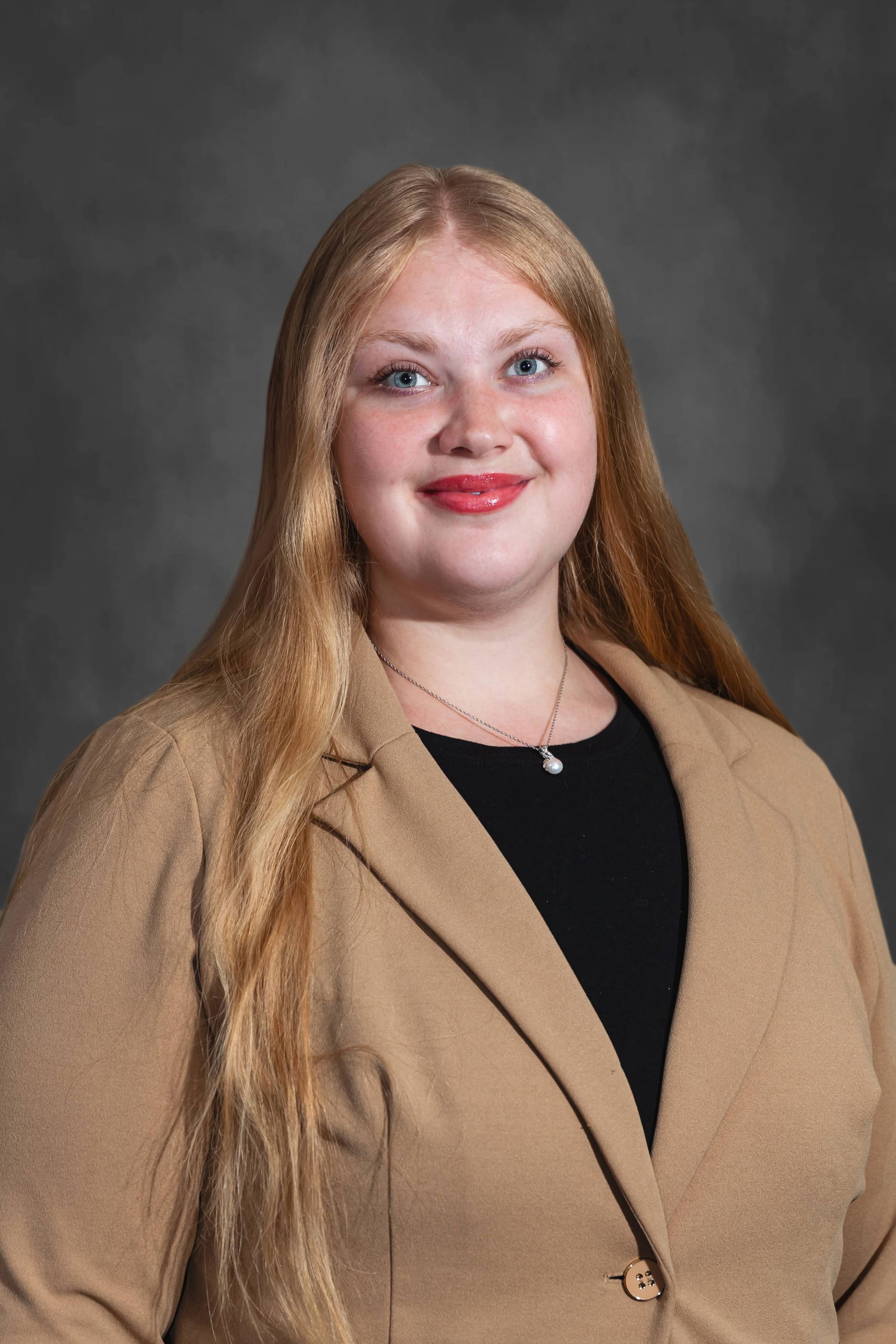 a woman with long blonde hair is smiling and wearing a black shirt .