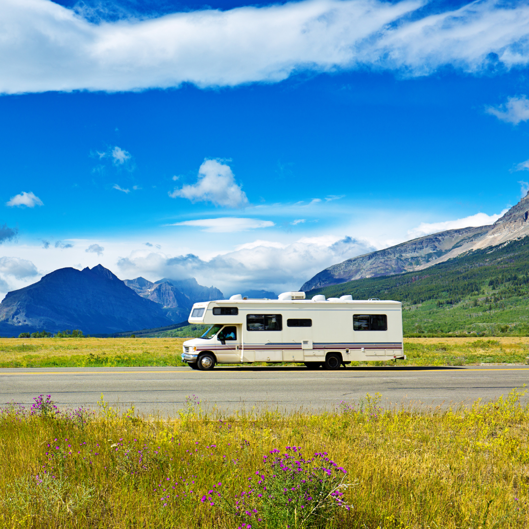 Camper driving on the road with mountains in the background