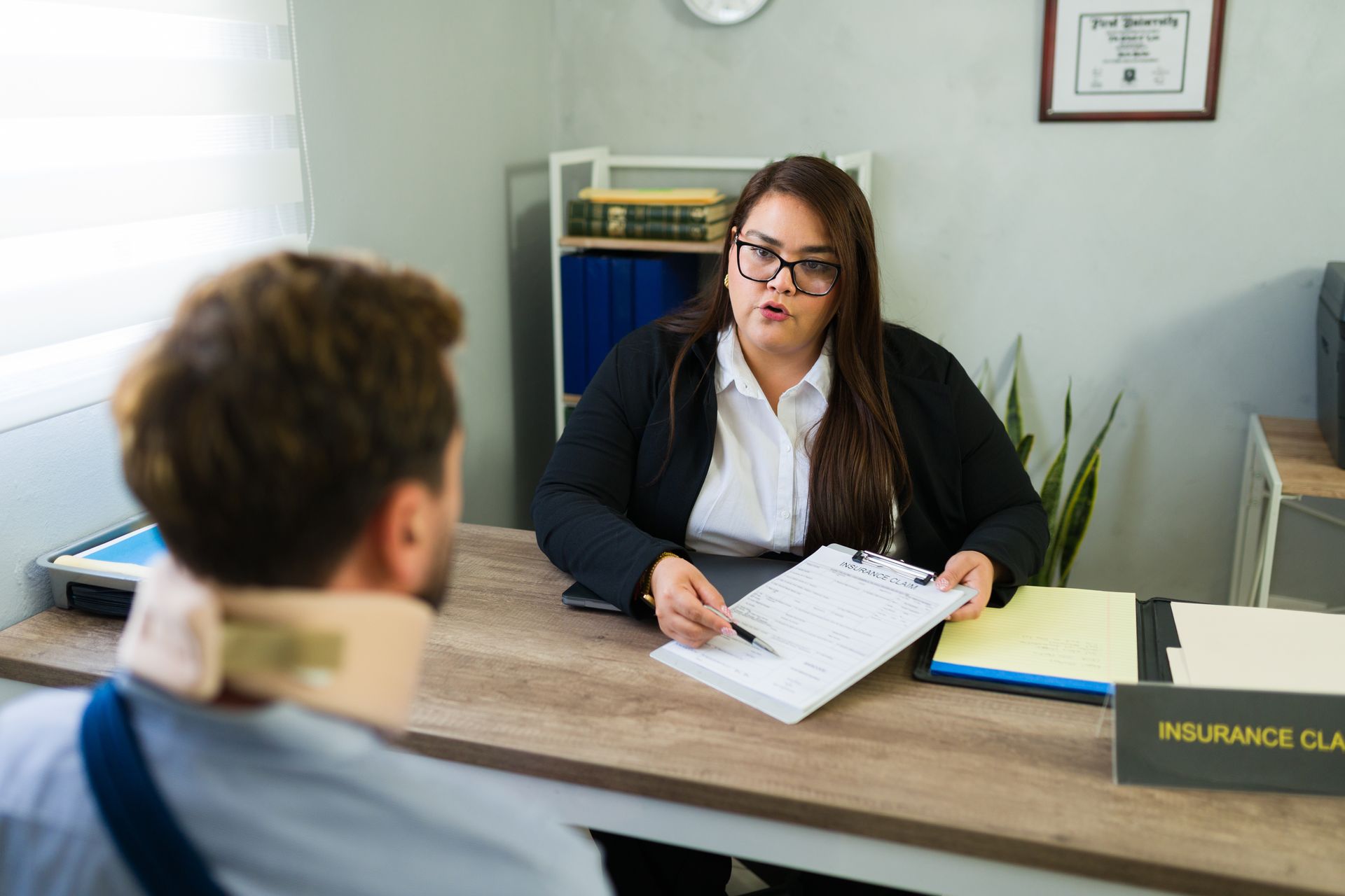 A female lawyer is discussing an insurance claim with an injured client.