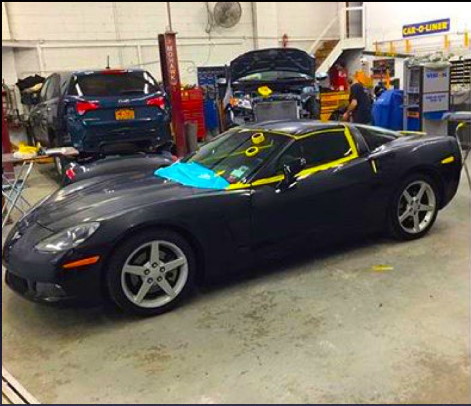 A black sports car is parked in a garage