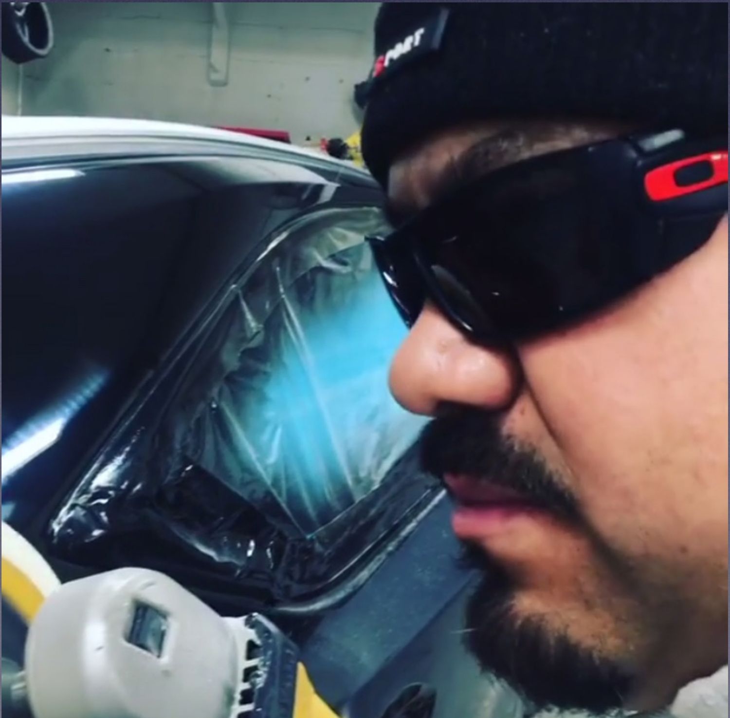 A man wearing sunglasses and a hat with the letter r on it