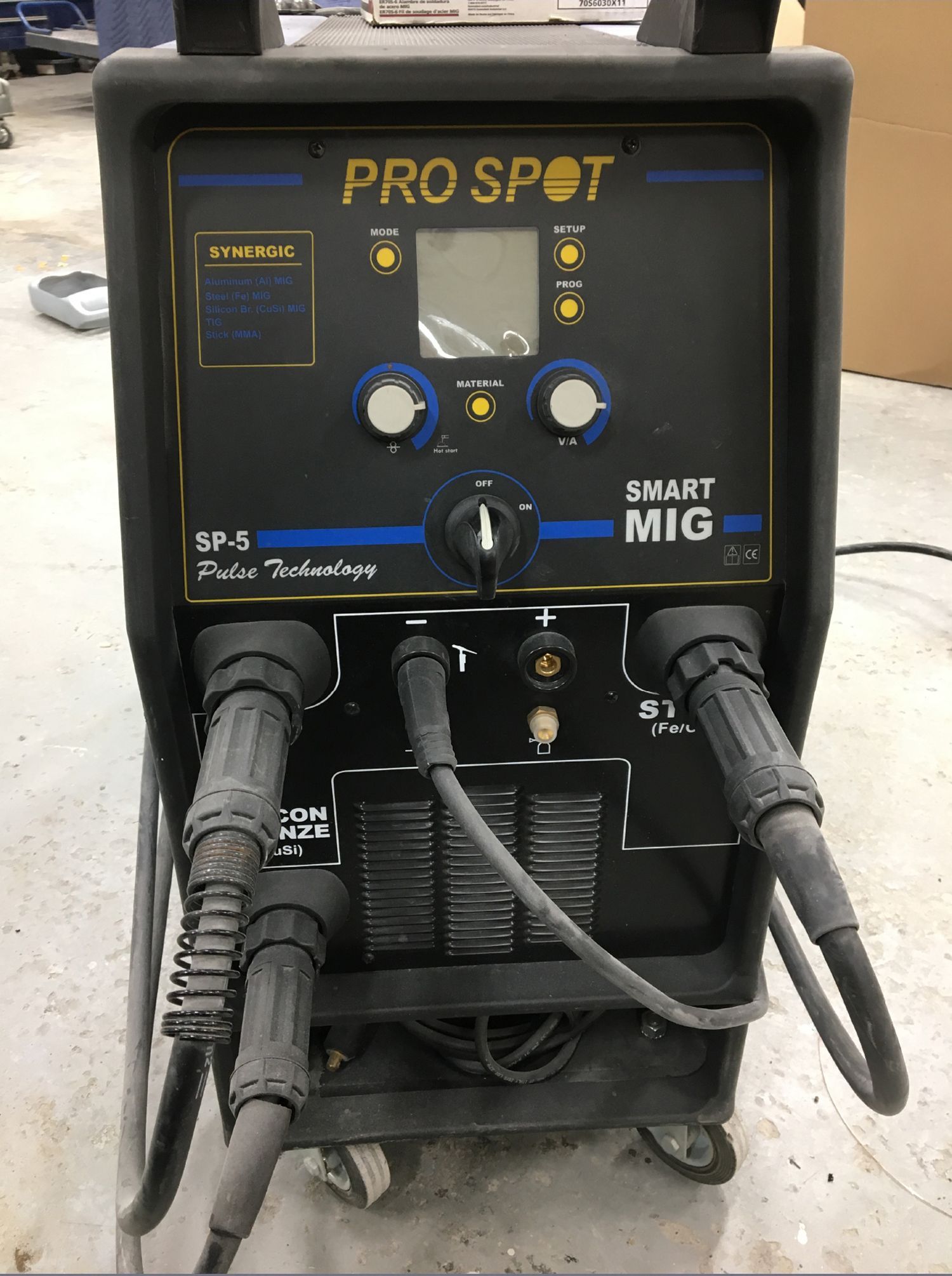 A pro spot smart mig welding machine is sitting on a cart.