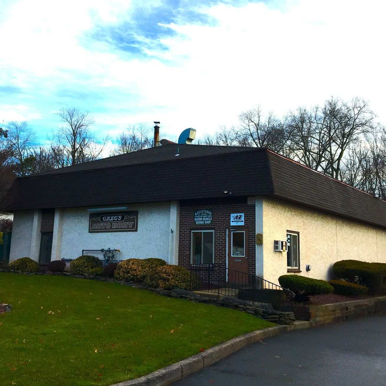 A white car is driving down a road at sunset - Congers, NY - Greg's Autobody