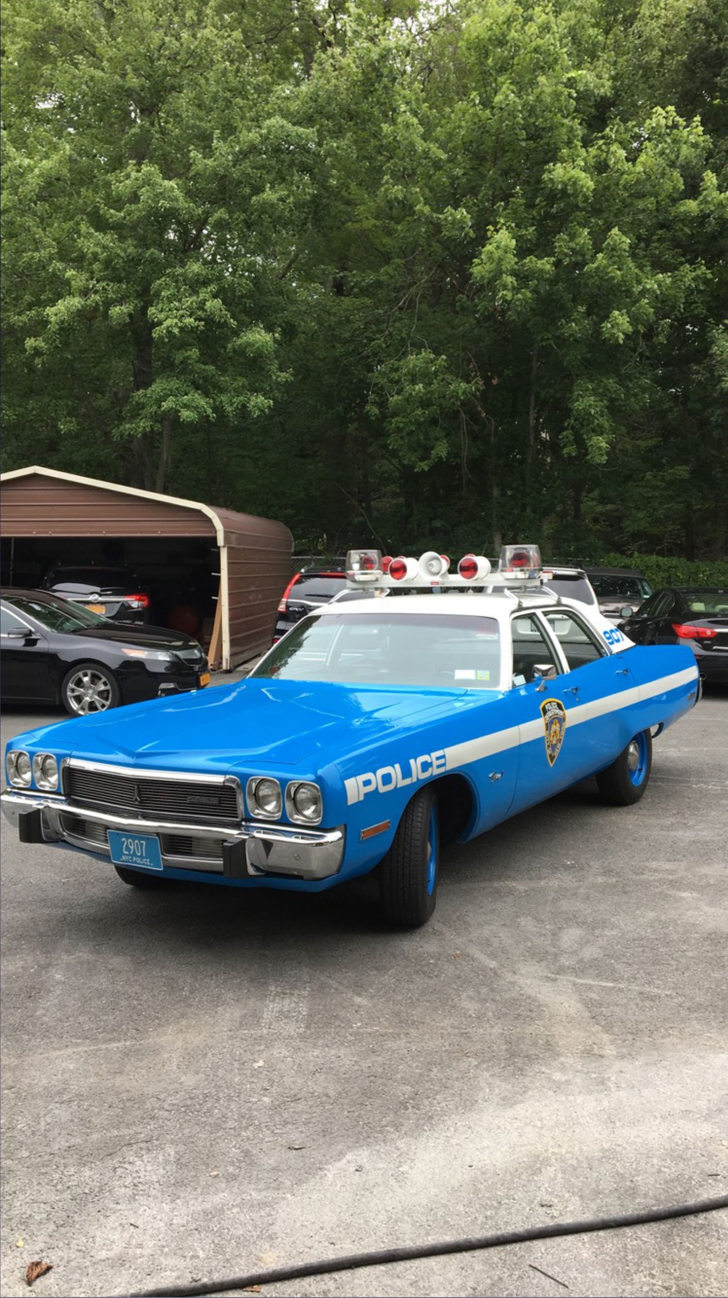 A blue and white police car is parked in a parking lot.