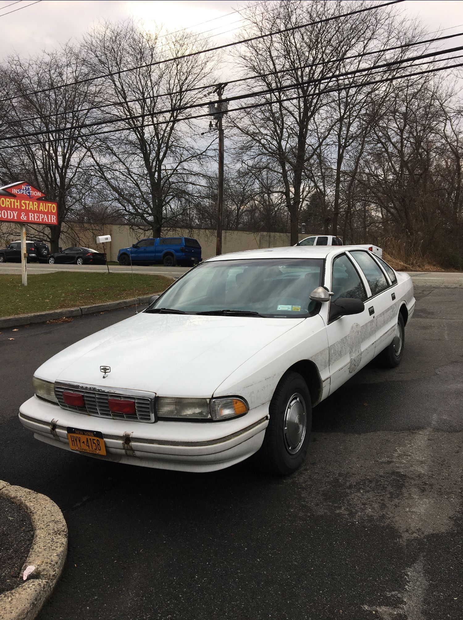 A white car is parked in a parking lot.