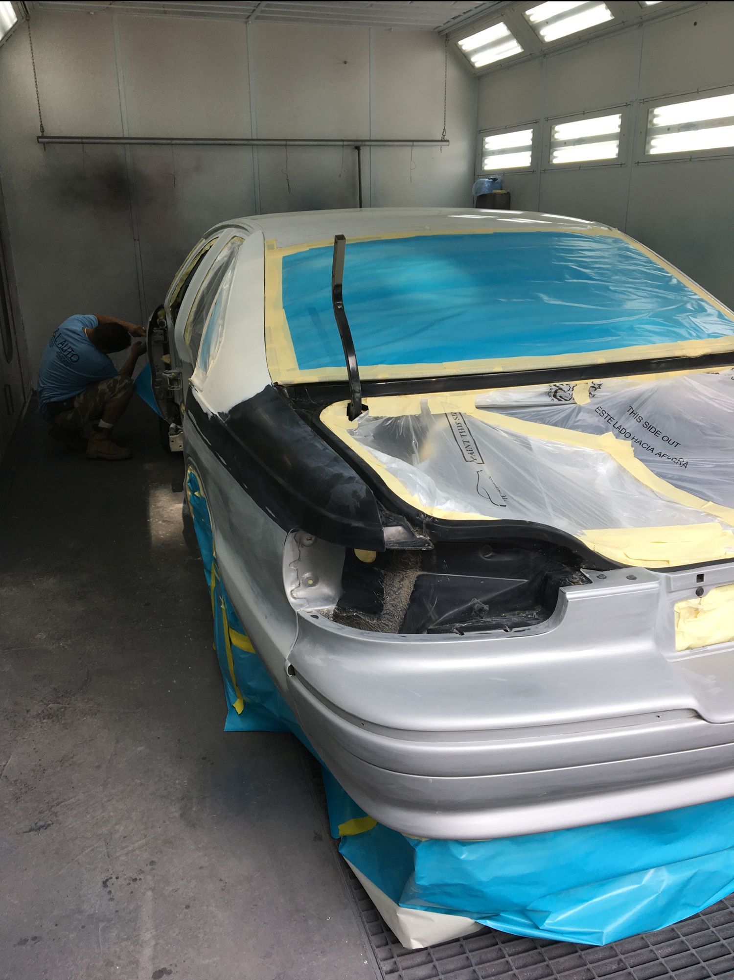 A car is being painted in a paint booth.
