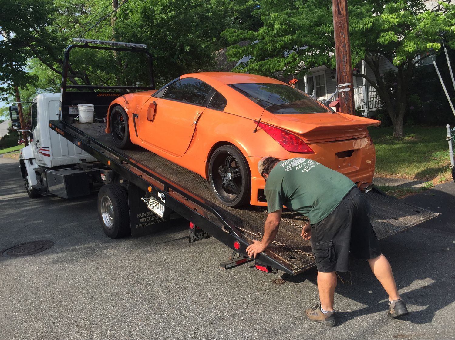 An orange sports car is being towed by a tow truck.