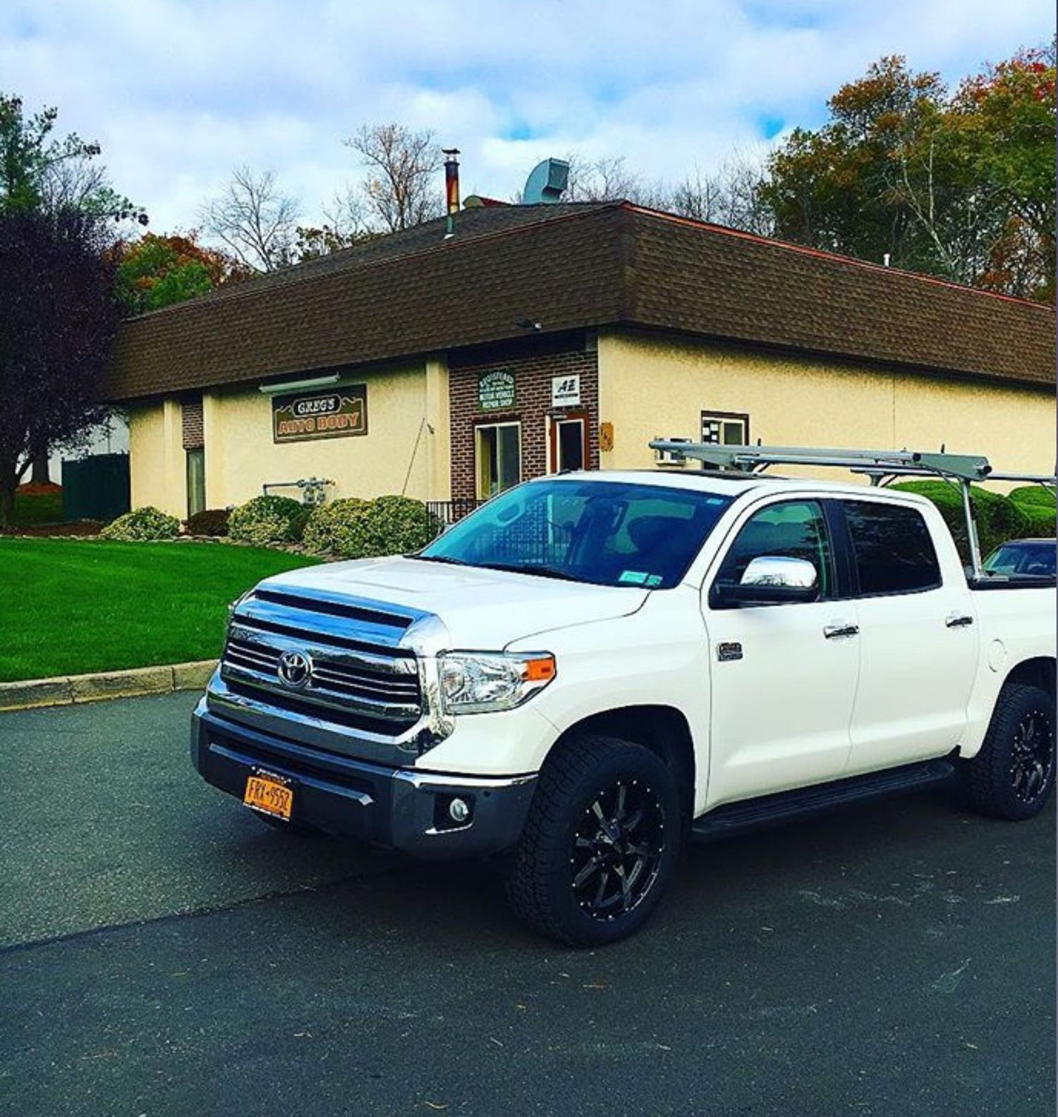 A white truck is parked in front of a building