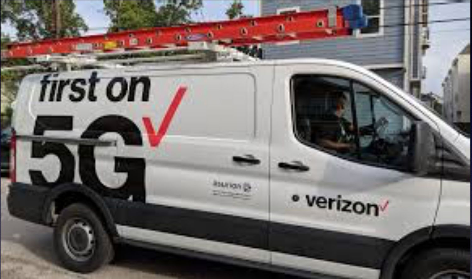 A verizon van is parked on the side of the road.