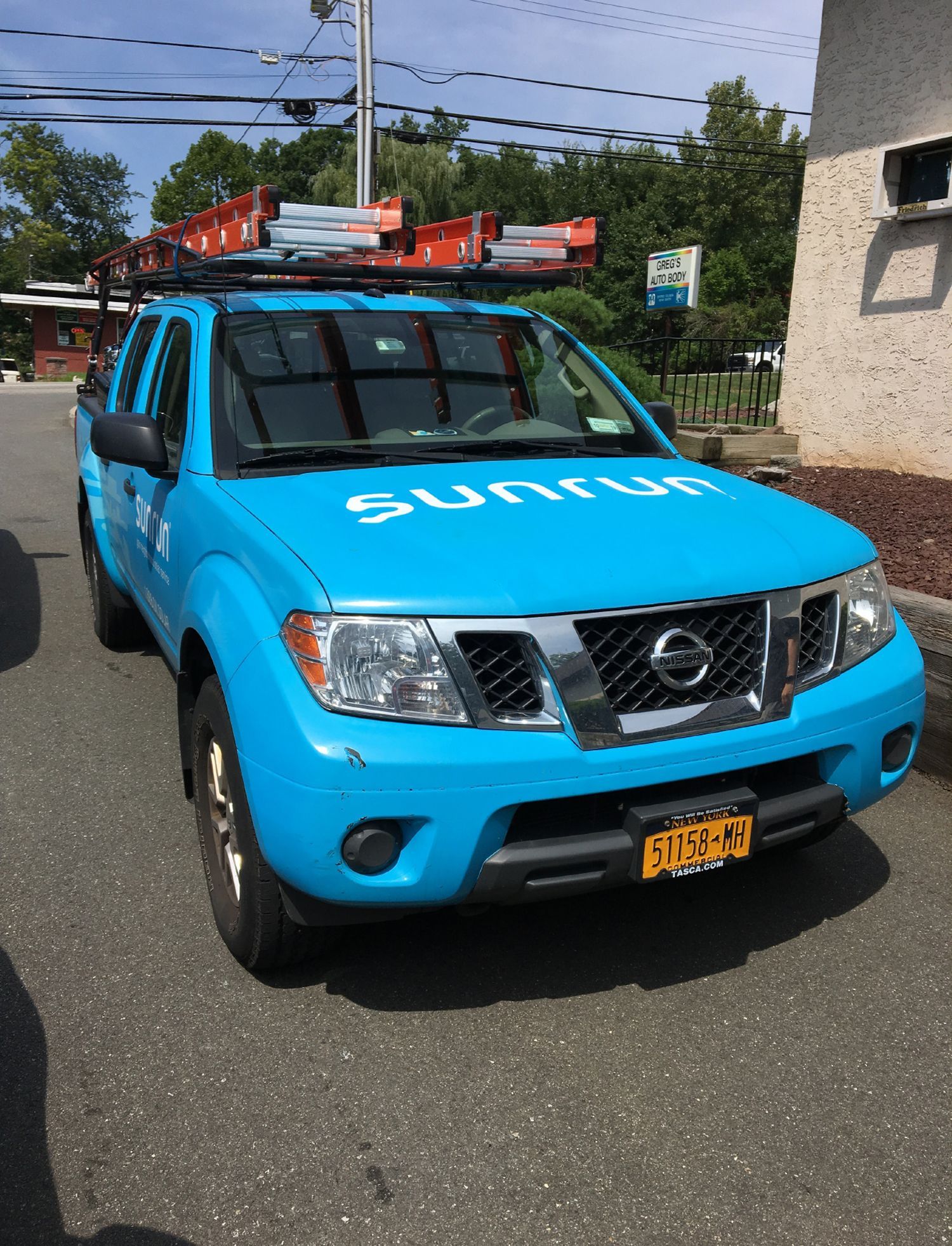 A blue nissan truck is parked on the side of the road