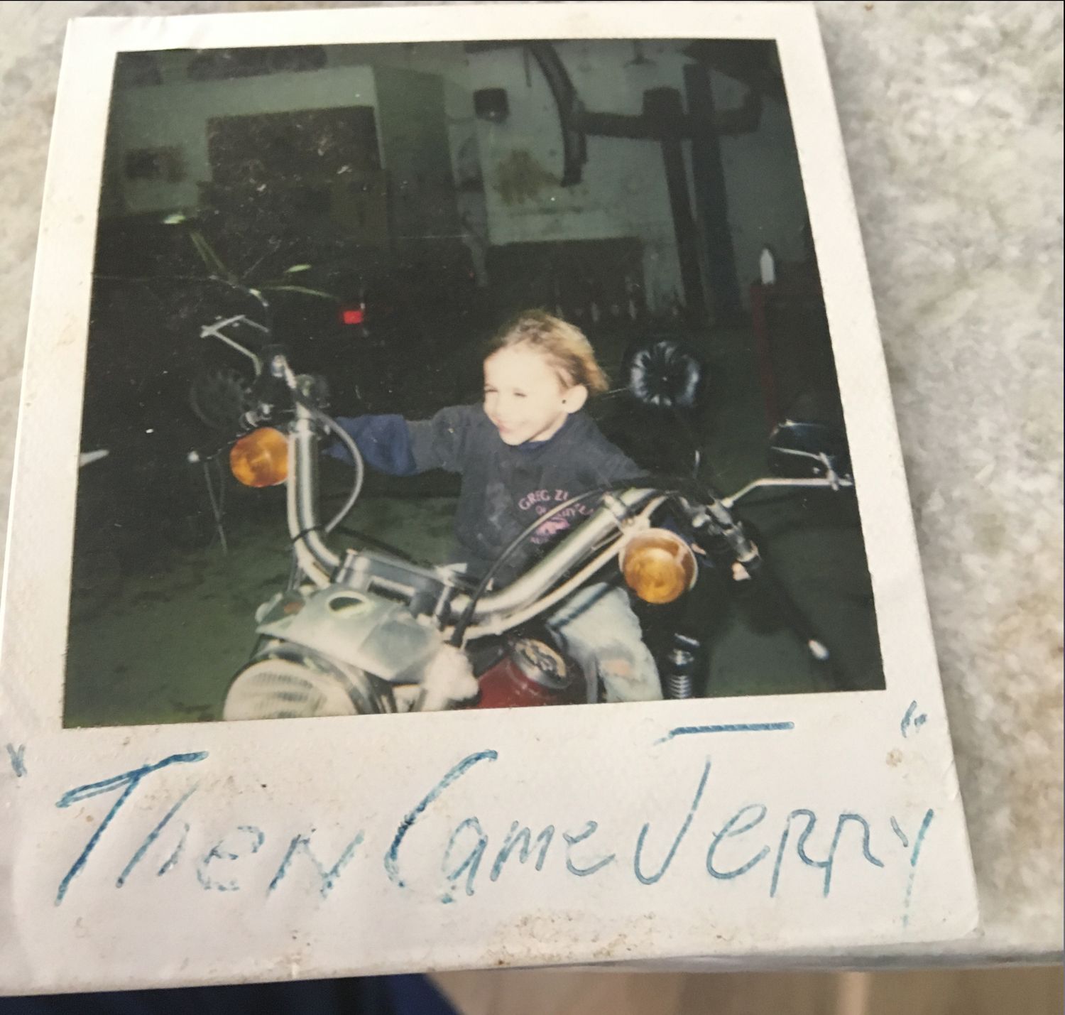 A picture of a child riding a motorcycle has the name jerry written on it