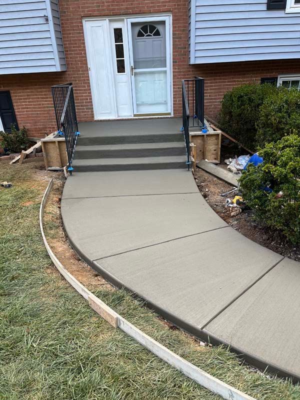 Newly poured concrete walkway and steps leading to a house entrance