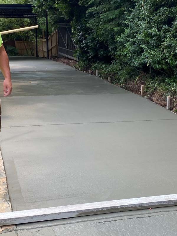 Freshly poured concrete driveway being leveled