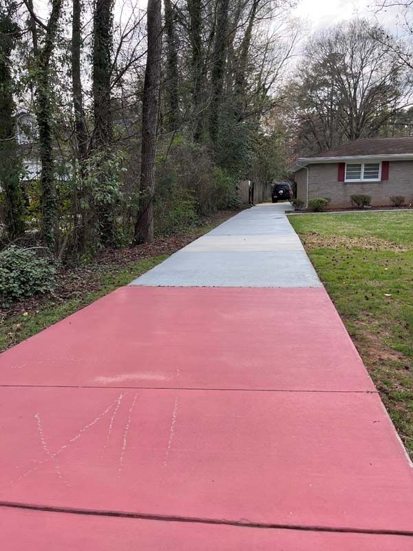 Red and gray painted driveway leading to a house