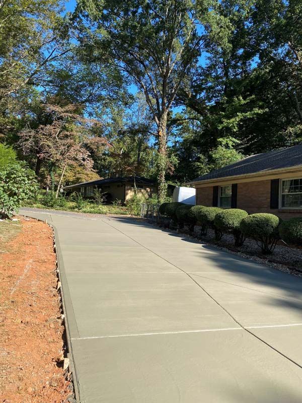 Newly poured concrete driveway in front of a brick house