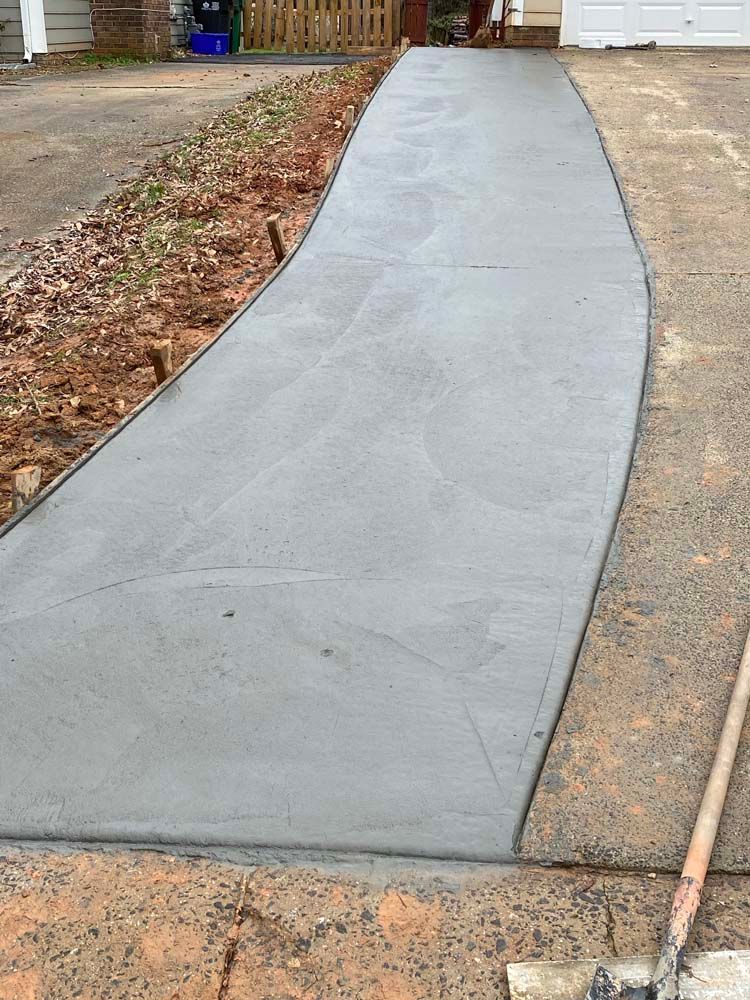 Newly poured gray concrete walkway with curved edges