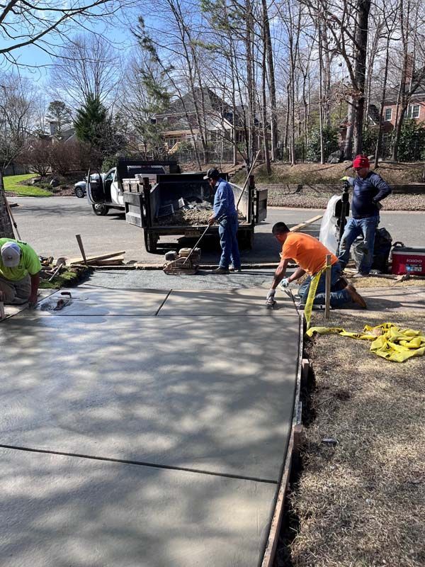 Construction workers pouring concrete on a driveway