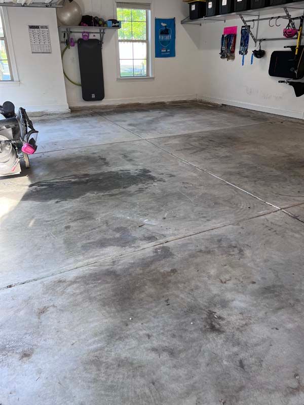 Concrete garage floor with dark stains and cracks