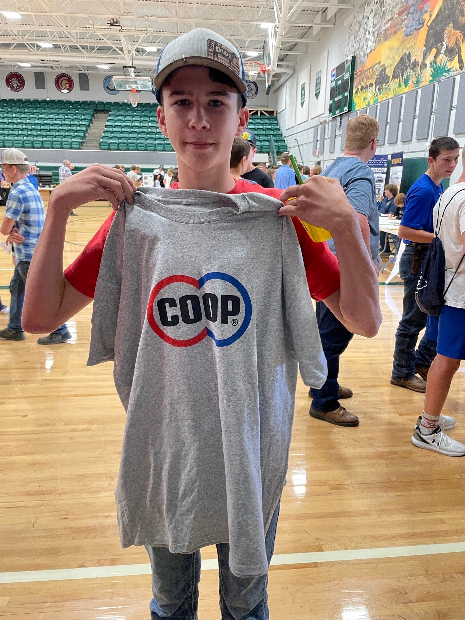 Teen holding a COOP shirt