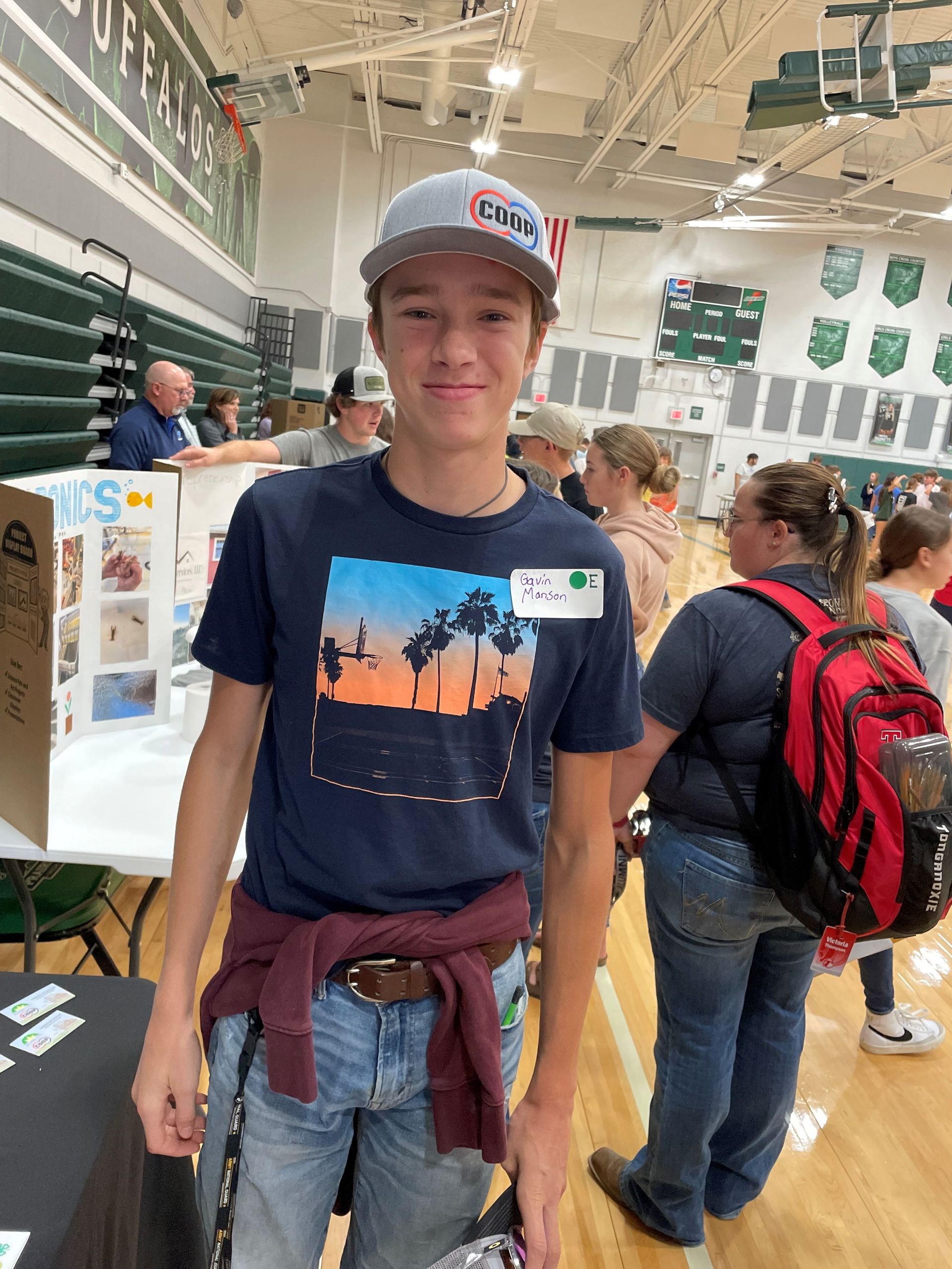 Teen wearing a COOP hat at a local ag event