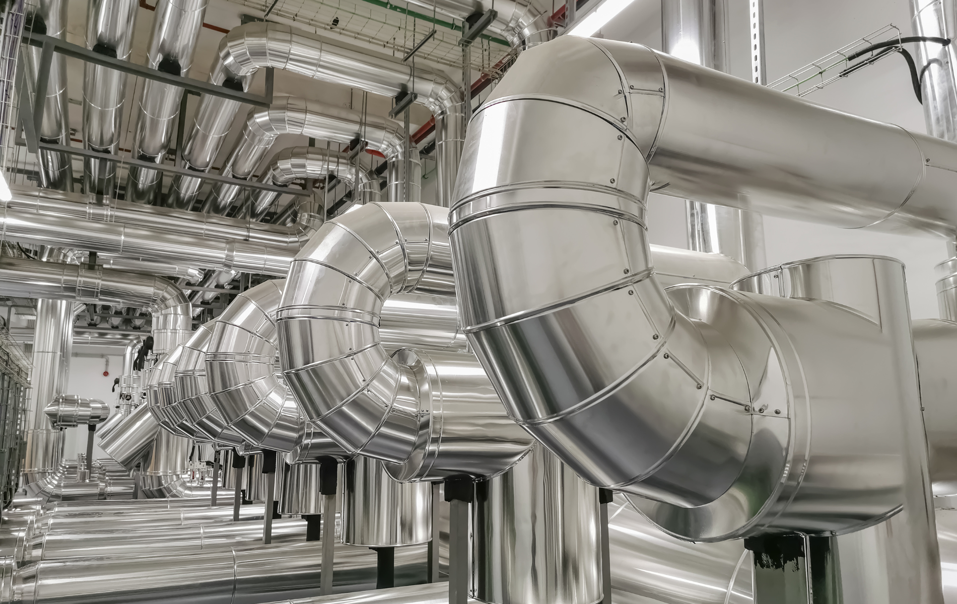 A row of stainless steel pipes in a factory.