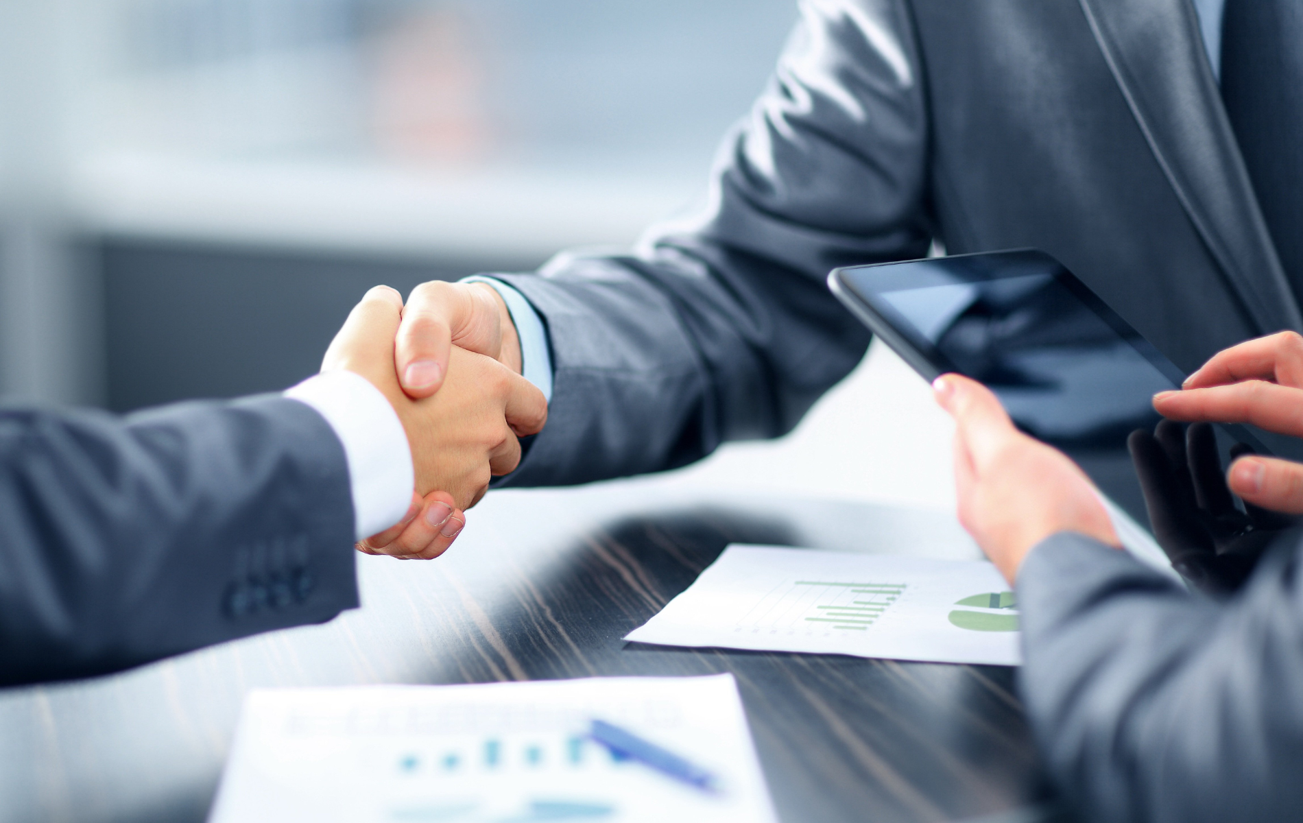A man in a suit is shaking hands with another man in a suit.