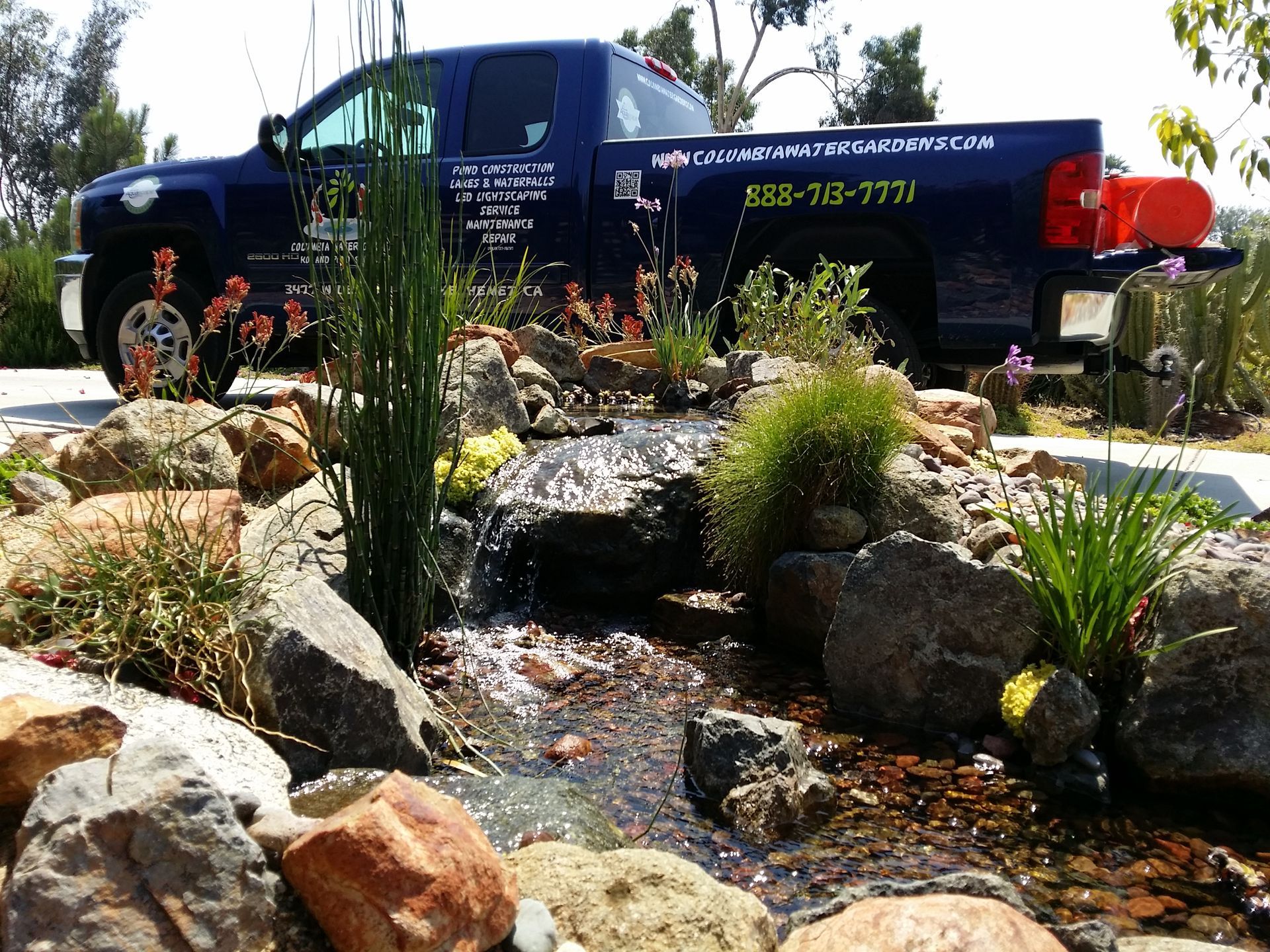 A blue truck with a phone number on the back of it