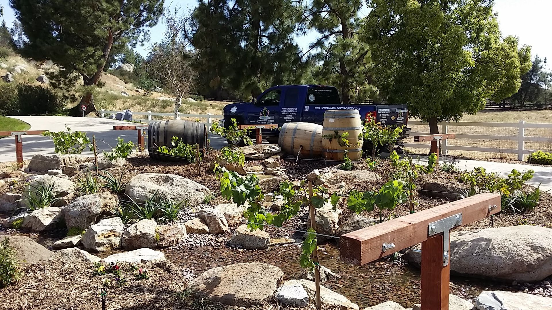 A blue truck is parked in a rock garden