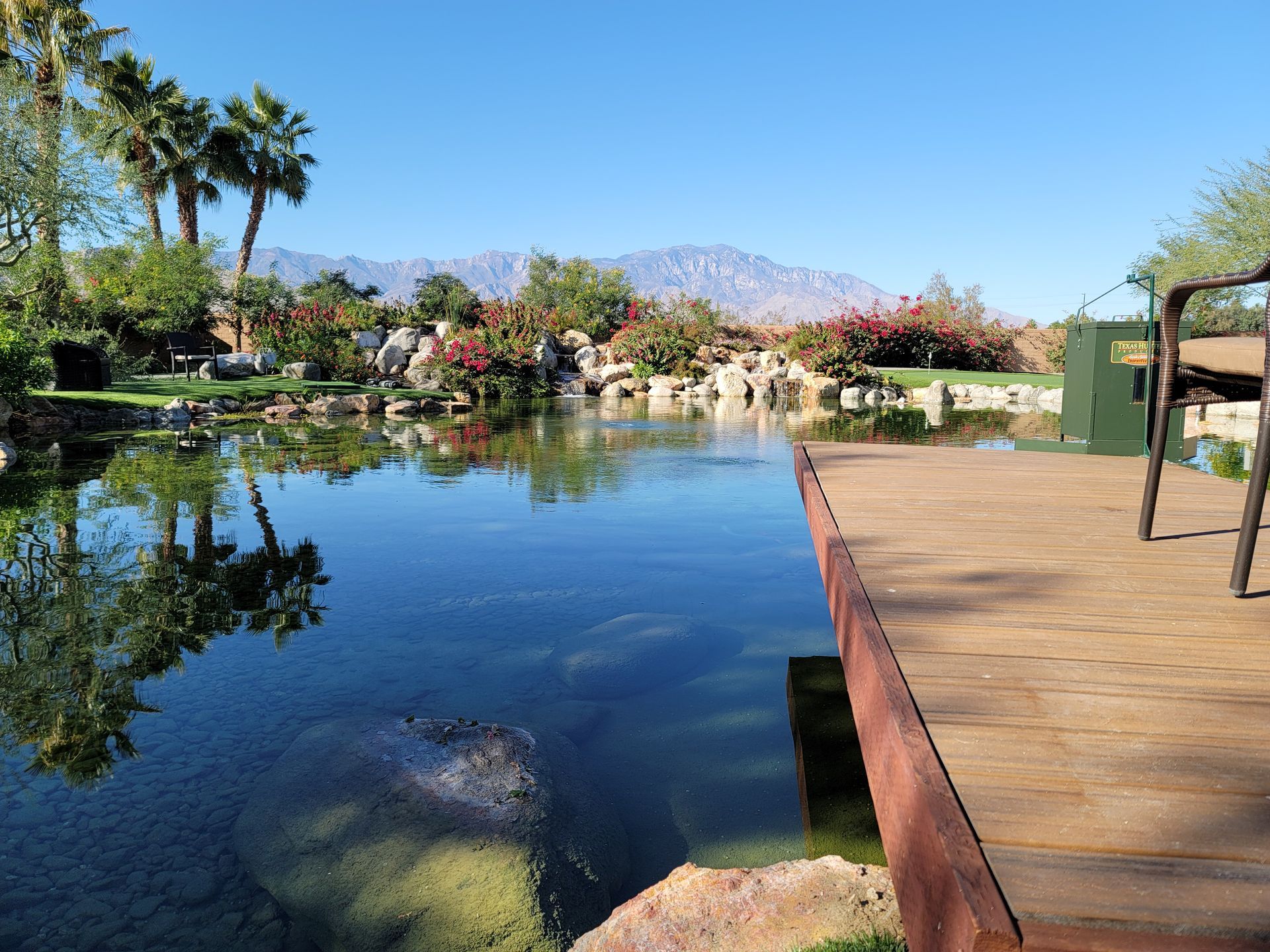 A wooden deck overlooking a lake with mountains in the background