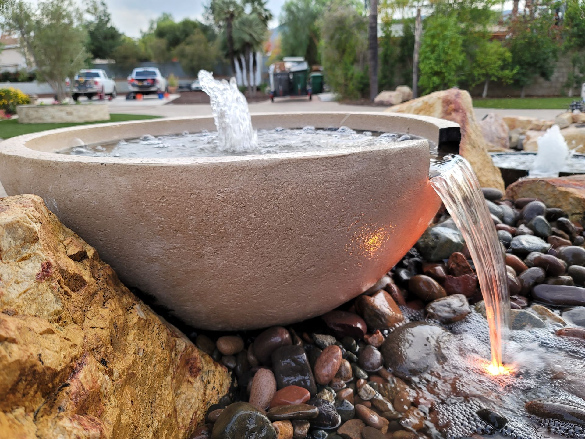 A fountain is surrounded by rocks and a bowl of water