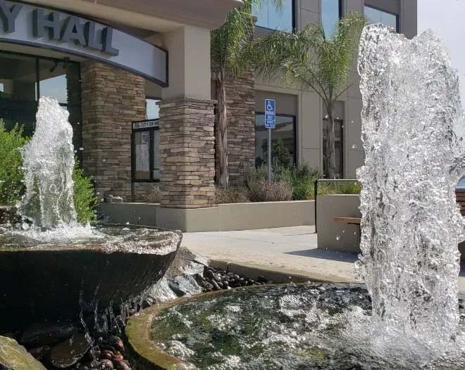 Fountains in front of City Hall building with water spraying up.