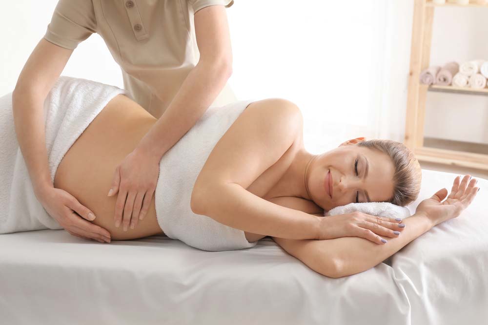 Beautiful Pregnant Woman Having Massage — Traditional Massage Services In Broadbeach, QLD