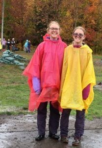 Two young ladies wearing raincoats smiling as they enjoy a day trip to Muskoka