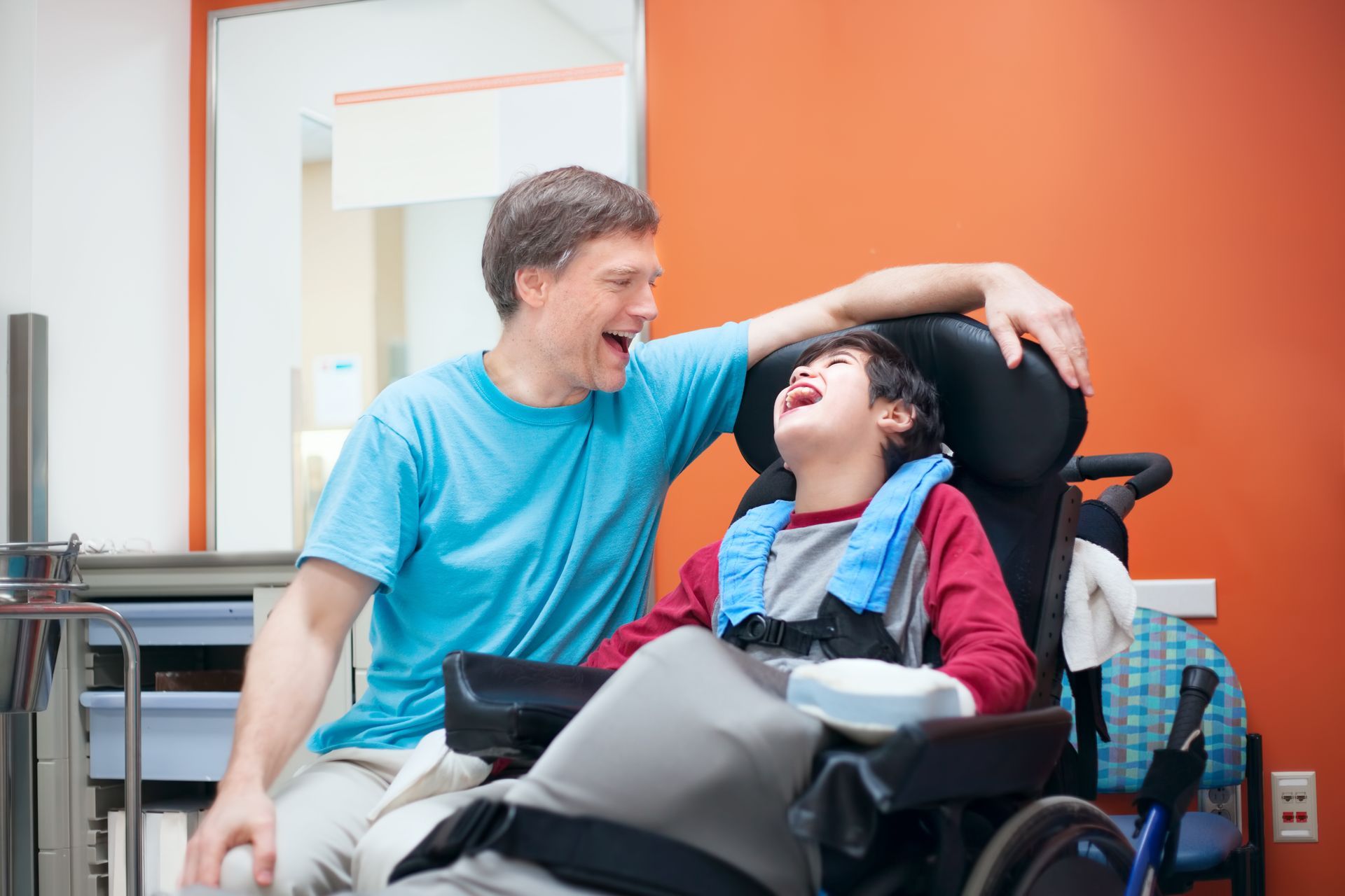 Adult shares a happy moment with a chid that has cerebral palsy