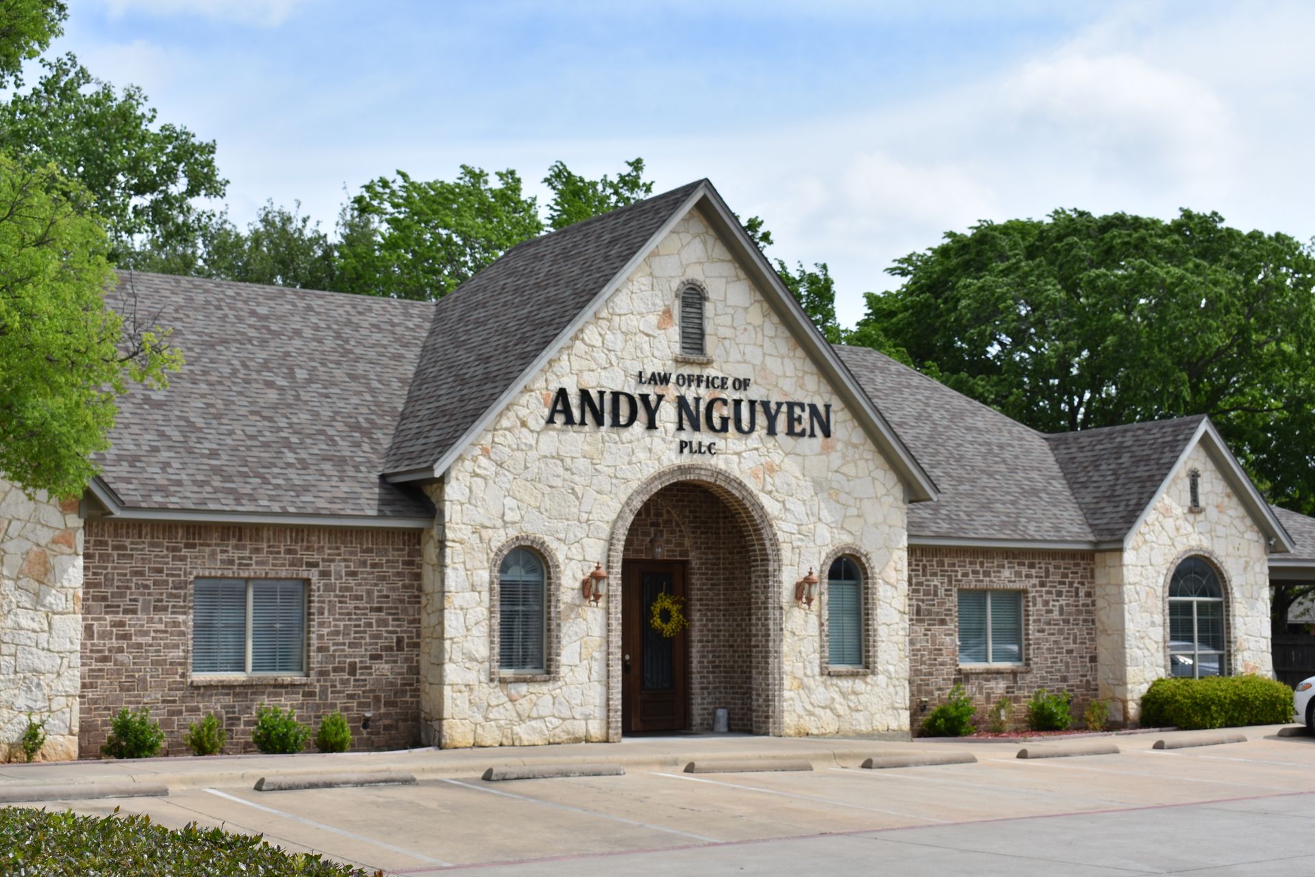 A large brick building with a gray roof and the name andy nguyen on it.