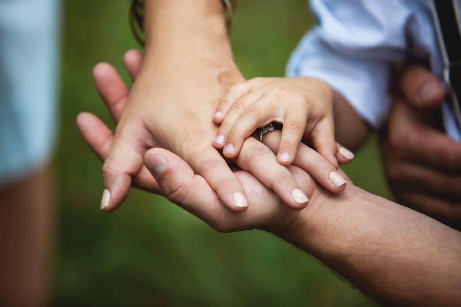 A family is putting their hands together and holding each other 's hands.