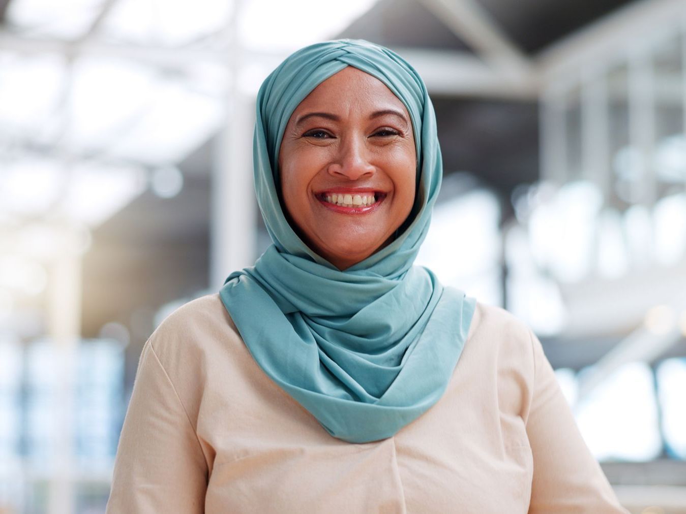 A woman wearing a hijab is smiling for the camera.