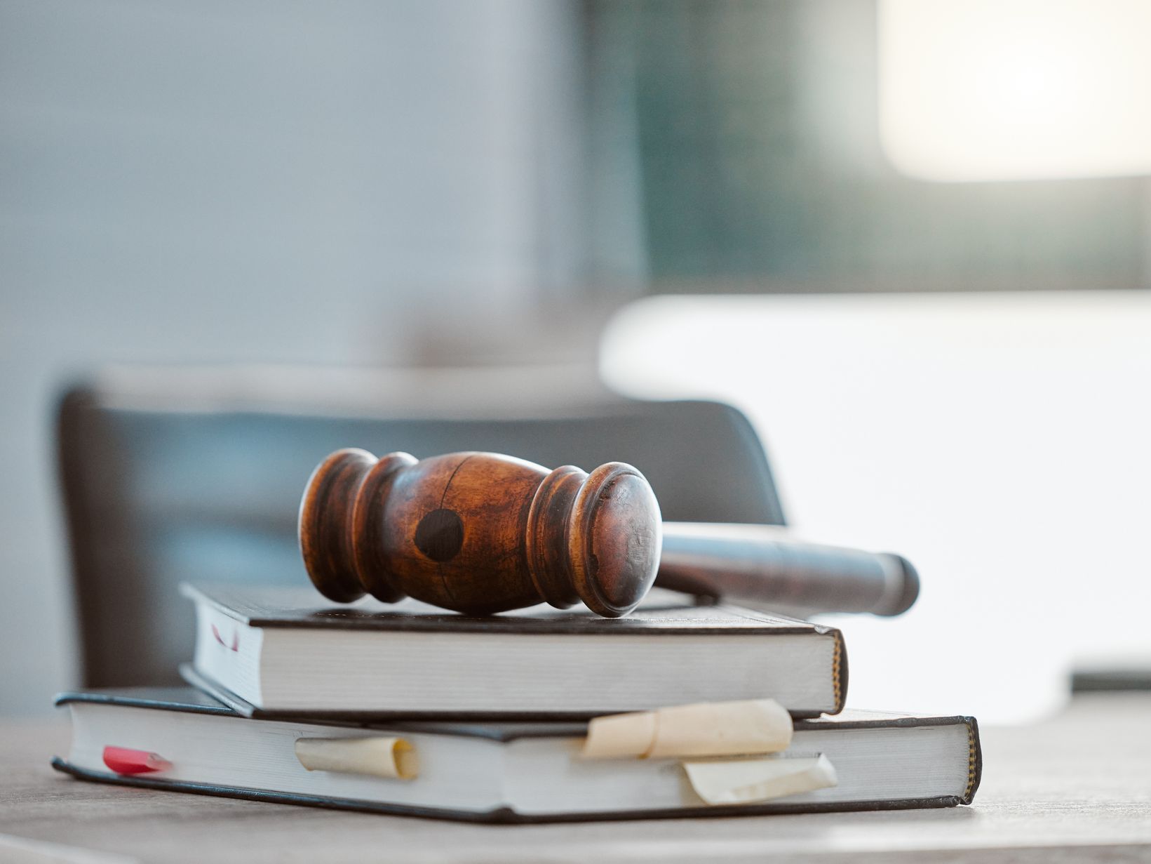 A wooden gavel is sitting on top of a stack of books.