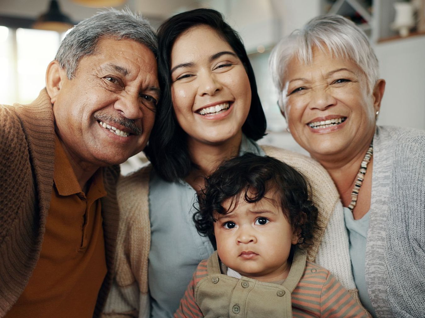 A family is posing for a picture with a baby.
