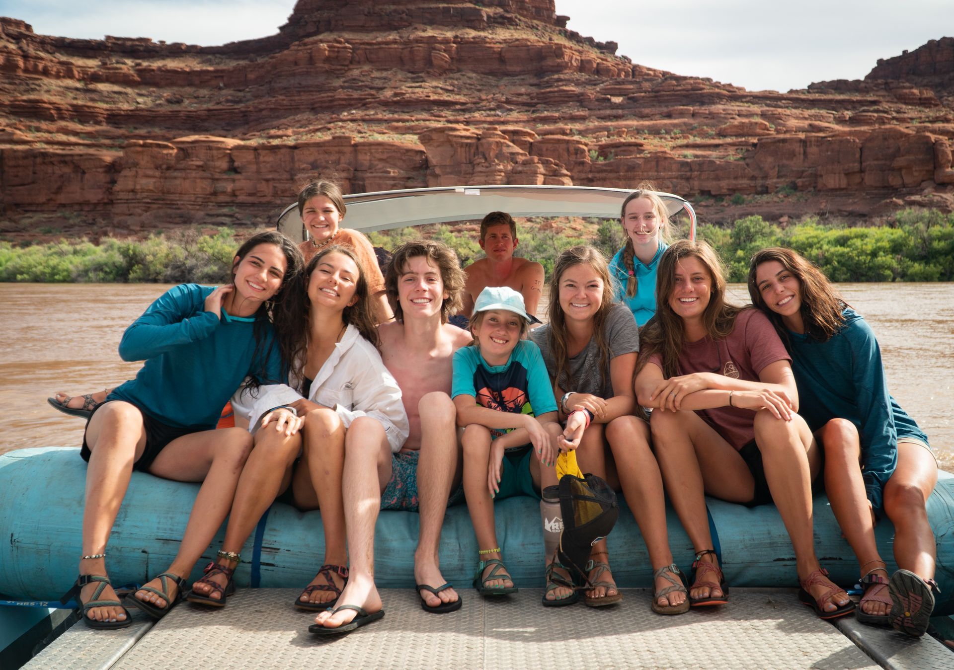 A group of people are sitting on a raft on a river.