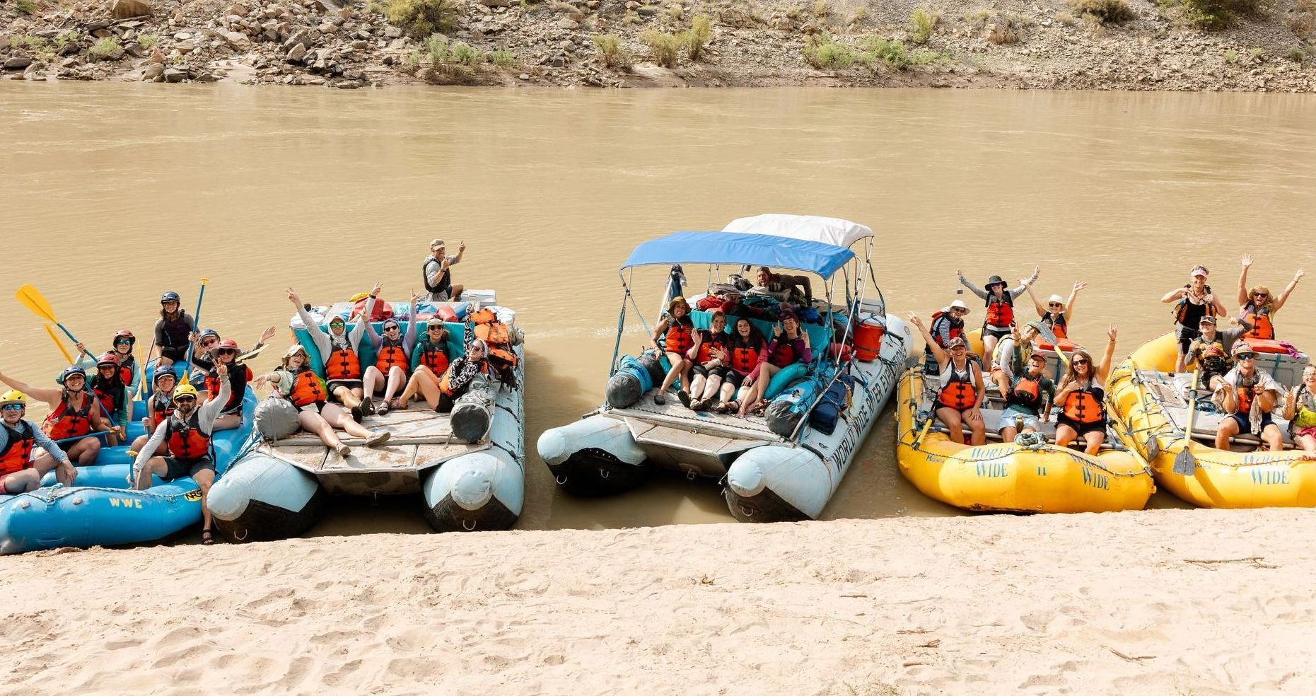 A large group of people are posing for a picture on top of a raft.