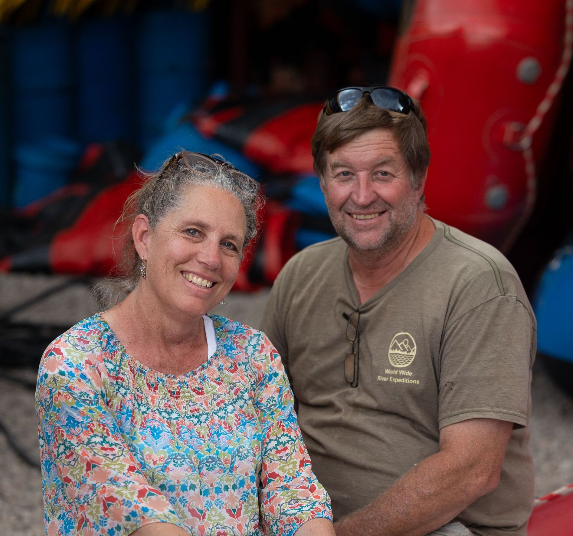 A man and a woman are posing for a picture in front of a mountain.