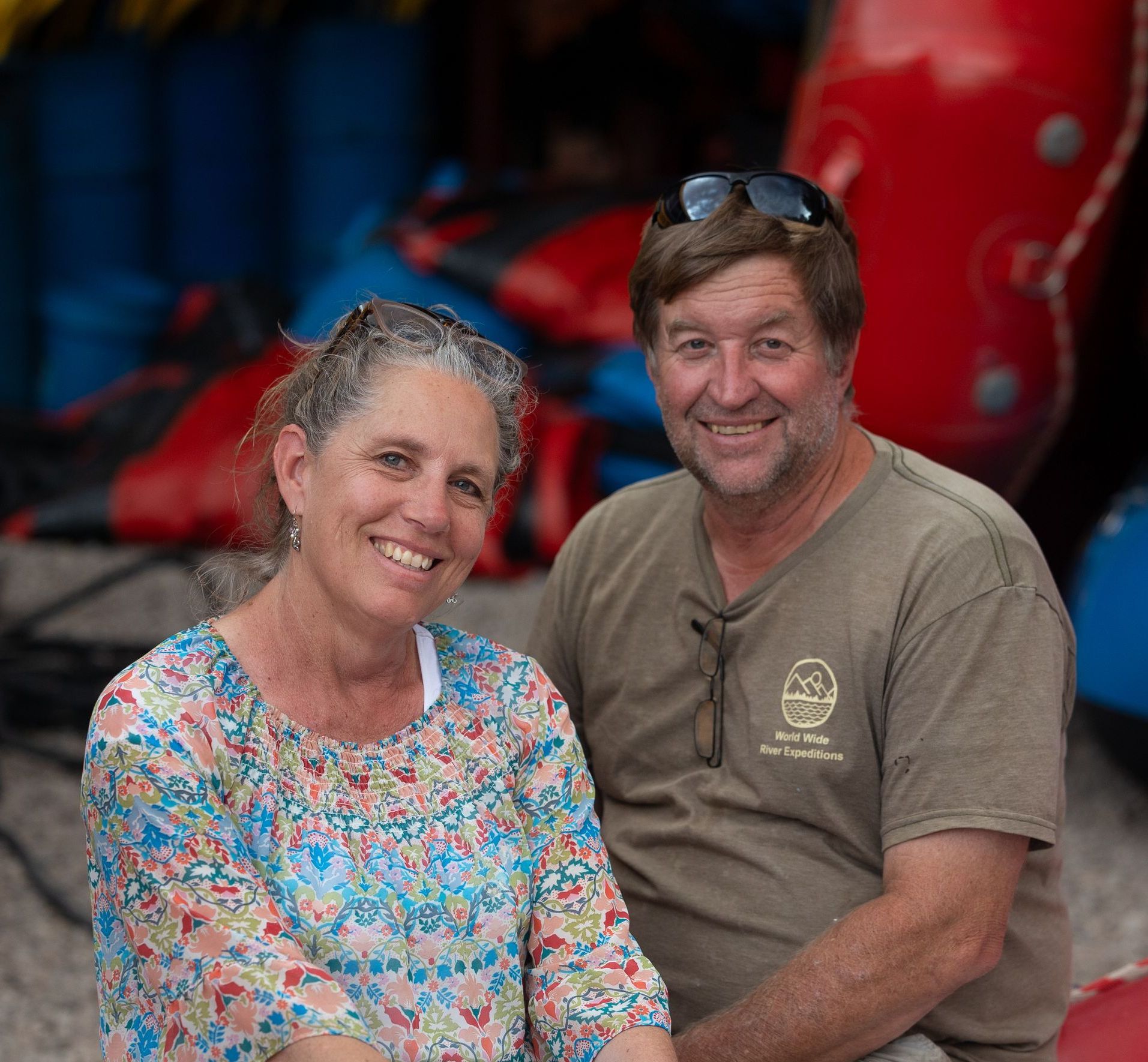 A man and a woman are posing for a picture in front of a mountain.